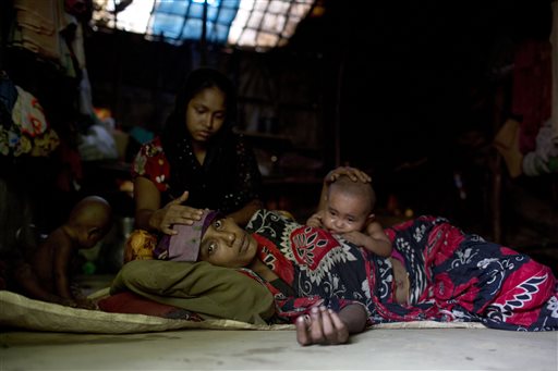 In this May 21, 2015, photo, Musammat Shahida, top, a Rohingya from Myanmar, takes care of her sister Musammat Somuda suffering from fever at a camp for Rohingya people in Ukhiya, near Cox's Bazar, a southern coastal district about 296 kilometers south of Dhaka, Bangladesh.  AP PHOTO/A.M. AHAD