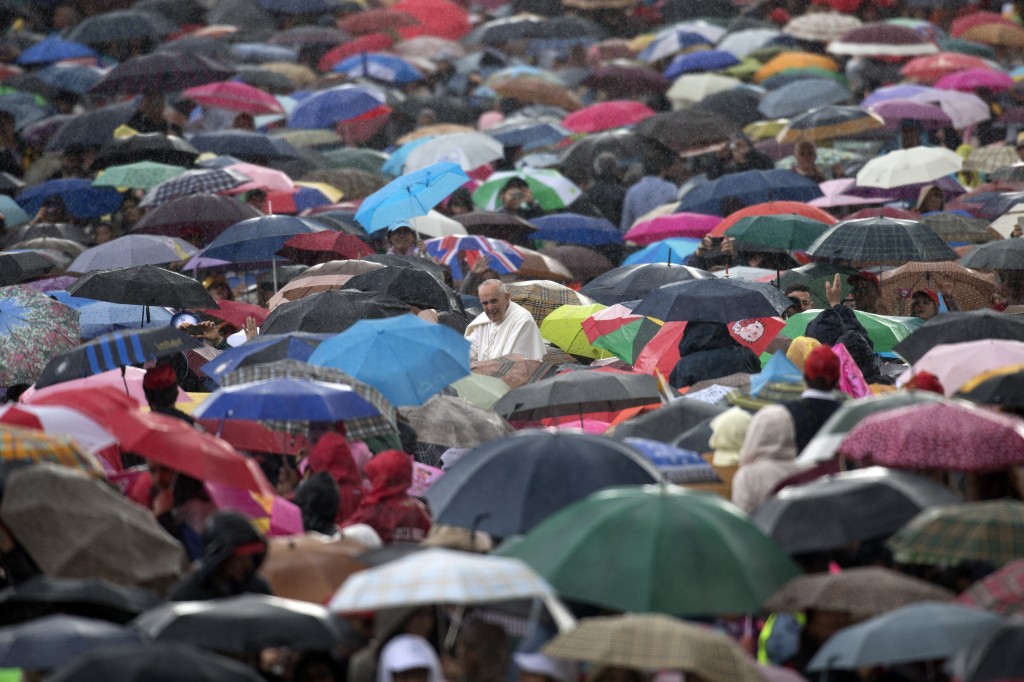 In this Wednesday, May 29, 2013, file photo, Pope Francis arrives for his weekly general audience in St. Peter's Square at the Vatican through a throng of people carrying umbrellas for the rain. Francis is issuing an encyclical on the environment and climate change by the end of June 2015 with an eye toward the end-of-year UN climate change conference in Paris.  AP PHOTO/ANDREW MEDICHINI