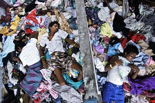 Ethnic Rohingya men take a nap on a pile of clothes donated by local residents at a temporary shelter in Langsa, Aceh province, Indonesia, Sunday, May 17, 2015. Boatloads of more than 2,000 migrants — ethnic Rohingya Muslims fleeing persecution in Myanmar and Bangladeshis trying to escape poverty — have landed in Indonesia, Malaysia and Thailand in recent weeks. The Philippines will push back to sea undocumented Asian “boat people” despite a United Nations appeal to Southeast Asian countries to open their ports to the migrants from impoverished Myanmar and Bangladesh, according to Malacañang.  AP PHOTO/BINSAR BAKKARA