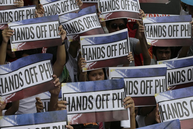 Protesters carry placards as they march in a Philippines Independence Day rally toward the Chinese Consulate in the financial district of Makati city east of Manila, Philippines, Friday, June 12, 2015. The protesters condemned the recent reclamation of land by China in the disputed Spratlys group of islands on the South China Sea. (AP Photo/Bullit Marquez)