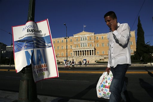 A man walks by a "YES" poster as speaks on his mobile phone in front of the parliament in central Athens, on Saturday, July 4, 2015. The Philippine Embassy in Athens is “preparing for the worst-case scenario” for Filipinos living in Greece as the country prepares for Sunday’s referendum on the financial bailout reform proposals of its creditors after it defaulted on its International Monetary Fund loan, Malacañang said on Saturday.  AP PHOTO/PETROS KARADJIAS 