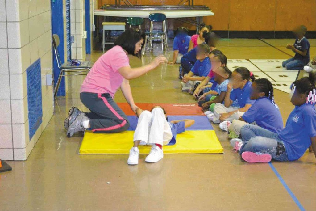 LET’S GET PHYSICAL Assisting a student in a physical education activity.