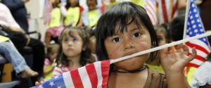 Estrella Manuel, 2, holds an American flag in her mouth during a news conference in Miami Wednesday, June 17, 2009.  Roughly 150 children are suing President Barack Obama to halt the deportations of their parents until Congress overhauls U.S. immigration laws. The U.S.-born children say their constitutional rights are being violated because they, too, will likely have to leave the country if their parents are forced to leave. (AP Photo/Lynne Sladky)