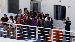 Filipino nationals pose for photos with a crew member on the deck of the MV Bridge after it arrived from Libya in Valletta's Grand Harbour August 15, 2014. More than 1,000 Philippine and Indian workers were evacuated to Malta on Friday from Libya, whose parliament has sought United Nation help to protect civilians from fighting between armed factions. REUTERS/Darrin Zammit Lupi (MALTA - Tags: CIVIL UNREST POLITICS MARITIME)