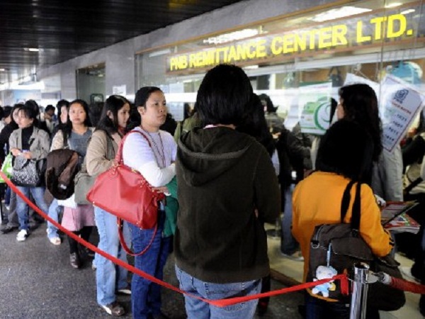 Filipino domestic helpers line up to send money at a remittance center in the central district of Hong kong on November 30, 2008, Remittances sent home by overseas Filipino workers grew 16.9 percent year on year in September despite earlier fears the global financial crisis could see a decline, the central bank said. They sent back 1.3 billion USD during the month, while the total for the first nine months of the year reached 12.3 billion USD, up 17.1 percent from a year ago, the central bank said.   AFP PHOTO/TED ALJIBE