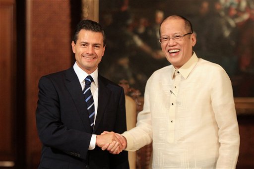 Philippine President Benigno Aquino III, right, shakes hands with Mexican President Enrique Peña Nieto signs the official guestbook inside the Malacañan Palace in Manila, Philippines, Tuesday, Nov. 17, 2015. President Enrique Peña Nieto is in the Philippines for the Asia-Pacific Economic Cooperation (APEC) summit.  (Rouelle Umali/Pool Photo via AP)