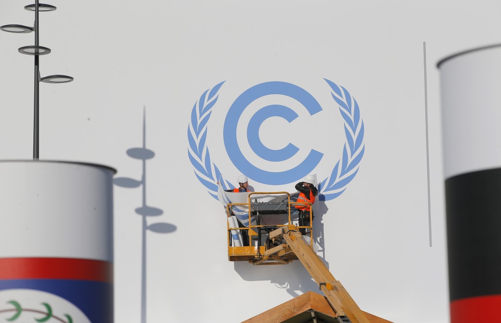 Workers install a logo on the facade of the U.N Climate Conference in Le Bourget, outside Paris, Monday Nov. 23, 2015. The conference with more than 100 heads of state is scheduled to start on Nov.30. (AP Photo/Christophe Ena)