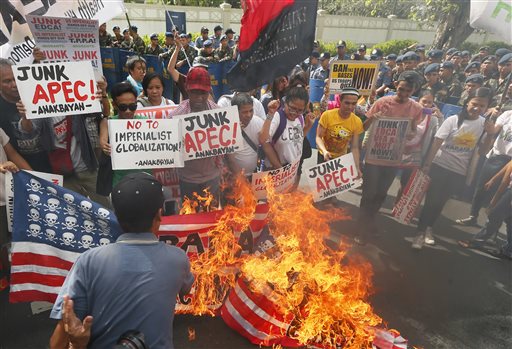 Protesters burn mock American flags during a rally outside the US Embassy to protest the alleged US military's involvement in the row between the Philippines and China on the disputed islands in the South China Sea, Thursday, Nov. 12, 2015 in Manila, Philippines. The protesters are opposing the visit of Chinese President Xi Jinping and US President Barack Obama next week to the APEC (Asia Pacific Economic Cooperation) Summit of Leaders. (AP Photo/Bullit Marquez)