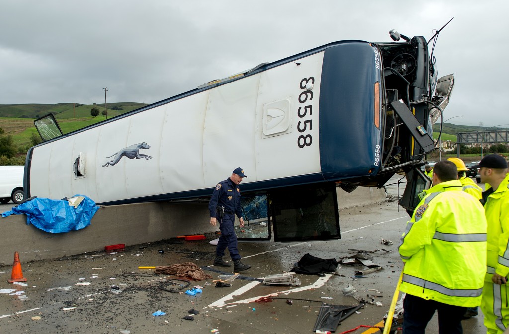 A California Highway Patrol investigator examines the scene of a fatal Greyhound bus crash, Tuesday, Jan. 19, 2016, in San Jose, Calif. The bus flipped on its side while traveling north on Highway 101, according to the San Jose Fire Department. (AP Photo/Noah Berger)