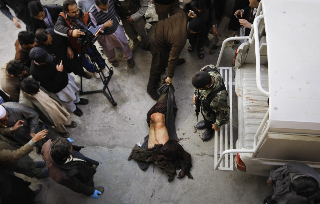 A Pakistani security personal drags the dead body of a terrorist following an attack at Bacha Khan University in Charsadda town, some 35 kilometers (21 miles) outside the city of Peshawar, Pakistan, Wednesday, Jan. 20, 2016. Gunmen stormed Bacha Khan University named after the founder of an anti-Taliban political party in the country's northwest Wednesday, killing many people, officials said. (AP Photo/Mohammad Sajjad)