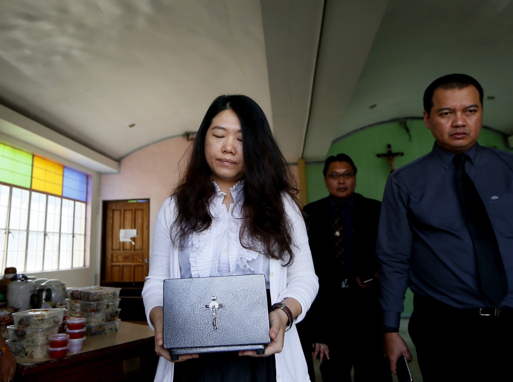 Chan Wai See, the widow of Malaysian hostage Bernard Then, carries the urn containing his ashes after cremation at suburban Pasay city Manila, Philippines, Friday, Jan. 15, 2016.  Then was kidnapped with a compatriot, Thien Nyuk Fun, by the Abu Sayyaf in May in Malaysia's Sabah state and taken by boat to the southern Philippine province of Sulu. Thien was freed but Then was found beheaded. (AP Photo/Bullit Marquez)