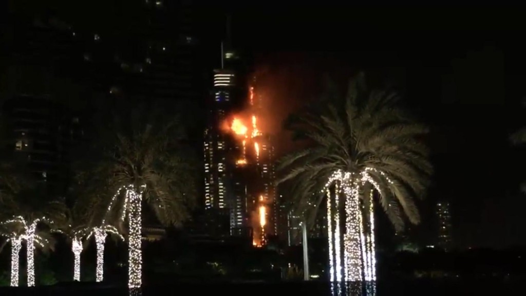 This image taken from AP video shows smoke and flames pouring from a residential building, which also contains the Address Downtown Hotel, in Dubai, United Arab Emirates, Thursday evening, Dec. 31, 2015. (AP Photo/Jon Gambrell)