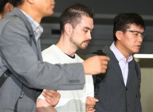 FILE - In this Sept. 23, 2015, file photo, Arthur Patterson, center, an American charged with murdering a Seoul university student in 1997, is escorted by South Korean police officers upon his arrival at Incheon International airport in Incheon, South Korea. South Korean prosecutors have asked for a 20-year prison term for Patterson charged with fatally stabbing a South Korean university student at a Seoul Burger King restaurant. Prosecutors made the request Friday, Jan. 15, 2016, at the end of the new trial of Patterson from California, according to spokesman Joon Young Maeng at the Seoul Central District Court. (Im Hun-jung/Yonhap via AP) KOREA OUT