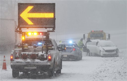 An accident victim removes belongings from their car along interstate 95 near Richmond, Va., Friday, Jan. 22, 2016. A massive blizzard began dumping snow on the southern and eastern United States on Friday, with mass flight cancelations, six states declaring states of emergency and more than two feet (60 centimeters) predicted for Washington alone. (AP Photo/Steve Helber)