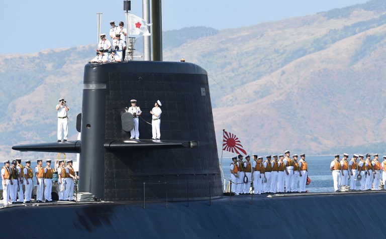 Crew members of Japanese submarine Oyashio stand on the deck as they arrive at the former US naval base in Subic bay, on April 3, 2016. Two Japanese destroyers and a submarine docked at a Philippine port April 3, near disputed South China Sea waters, where Beijing's increasingly assertive behaviour has sparked global concern. / AFP / TED ALJIBE