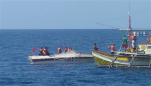 In this Feb.27, 2015 photo provided by Renato Etac, Chinese Coast Guard members approach Filipino fishermen as they confront them off Scarborough Shoal at South China Sea, also called the West Philippine Sea, in northwestern Philippines. More than once, Chinese coast guardsmen approached Etac's boat and pointed their rifles at him, but he says he knew they would not fire and risk starting a war.(Renato Etac via AP)
