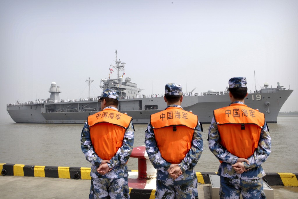 FILE - In this May 6, 2016, file photo, soldiers from the Chinese People's Liberation Army (PLA) Navy watch as the USS Blue Ridge arrives at a port in Shanghai. Seeking to calm escalating tensions in the South China Sea, top generals from China and the U.S. spoke by phone Thursday, May 12, 2016, and said they were ready to work out an effective mechanism to prevent confrontation and maintain stability in the region. (AP Photo, File)