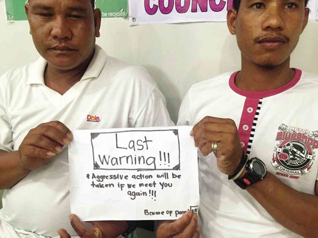 NELSON Plamiano (right) and Odelin Baisa, two of the three fishermen detained and manhandled by Malaysian Navy personnel, show the note that warns them against fishing near the Rizal (Commodore) Reef. The note was given them by a Malaysian navy man. CONTRIBUTED PHOTO