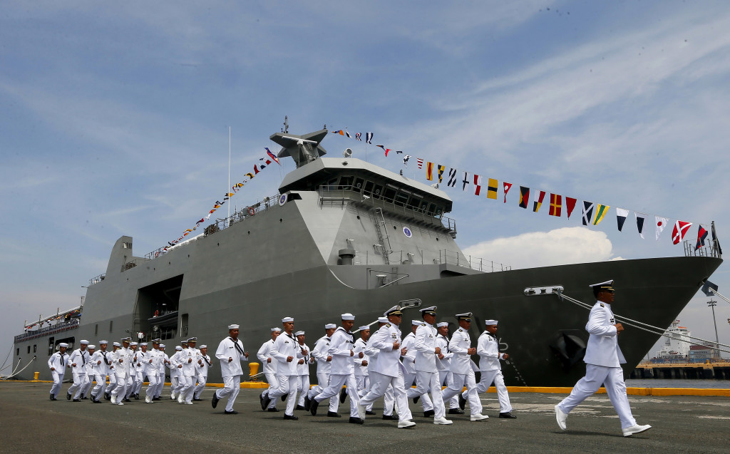 Crew of the new Philippine Navy Strategic Sealift Vessel BRP Tarlac (LD601) rush to board their vessel during the commissioning ceremony with three other vessels to coincide with the Philippine Navy's 118th anniversary Wednesday, June 1, 2016 at South Harbor in Manila, Philippines. The 7,200 ton ship is the country's largest to date and is capable of transporting personnel, equipment and aid during humanitarian assistance and disaster response operations. (AP Photo/Bullit Marquez)