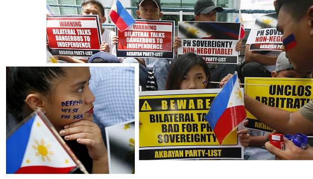 Protesters hold placards outside of the the Chinese Consulate to protest China's occupation and island-building in the disputed Spratlys island group in the South China Sea Friday, June 10, 2016 in Makati city's financial district east of Manila, Philippines. The protesters are calling on the new government to reject China's proposal of bilateral talks instead of the arbitration case filed by the Philippines in The Hague. (AP Photo/Bullit Marquez)