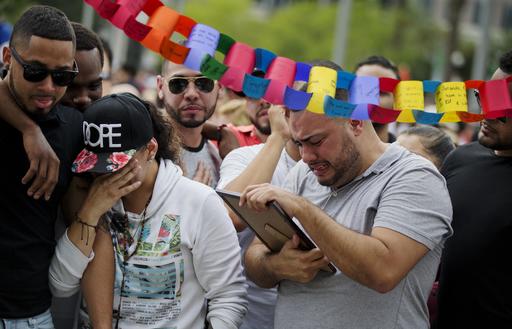 Jose Hernandez, right, cries as he looks at a photo of his friend Amanda Alvear, who was killed in the mass shooting at the Pulse nightclub, as he visits a makeshift memorial with friends, Monday, June 13, 2016, in Orlando, Fla. A gunman killed dozens of people in a massacre at a crowded gay nightclub in Orlando on Sunday, making it the deadliest mass shooting in modern U.S. history.  AP Photo