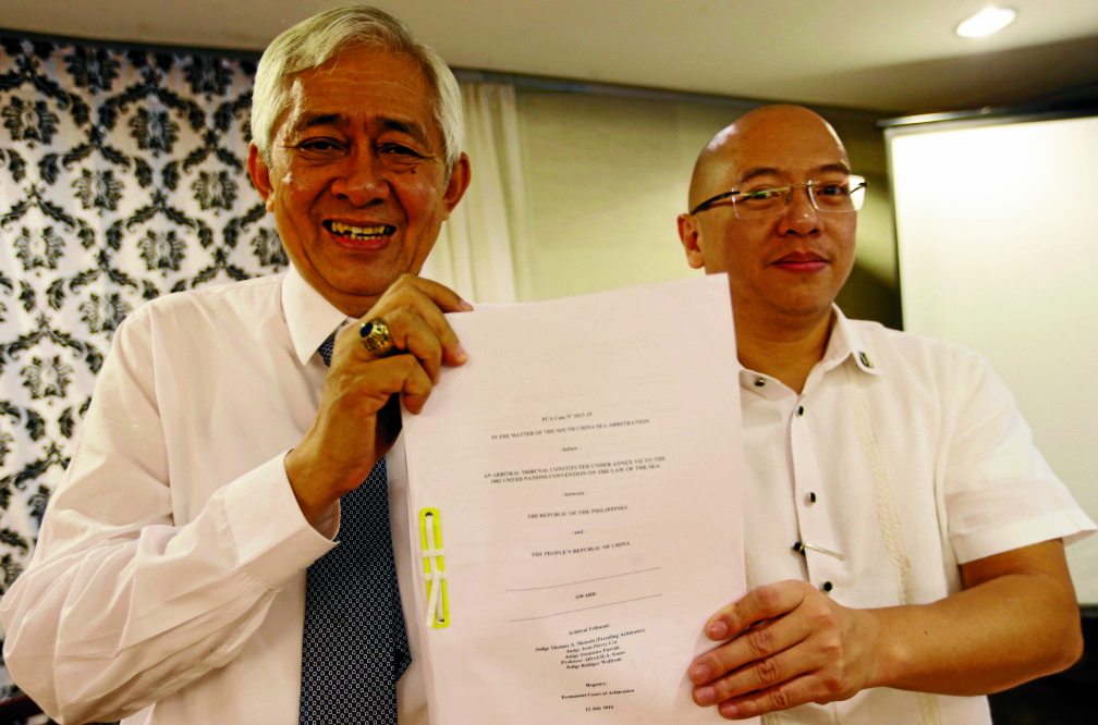 Associate Justice of the Supreme Court Francis Jardeleza, left, and former Solicitor General Florin Hilbay hold a photocopy of the Hague-based U.N. international arbitration tribunal ruling favoring the Philippines in its case against China on the dispute on South China Sea following a news conference Wednesday, July 13, 2016 in Manila, Philippines. The Permanent Court of Arbitration (PCA) issued its ruling Tuesday in The Hague in response to an arbitration case brought by the Philippines against China regarding the South China Sea, saying that any historic rights to resources that China may have had were wiped out if they are incompatible with exclusive economic zones established under a U.N. treaty. Jardeleza and Hilbay were members of the Philippine team who filed the case against China in The HagueEDWIN BACASMAS