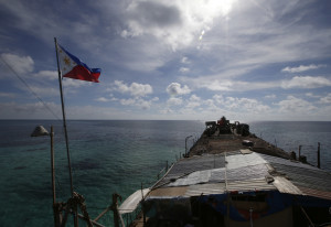 In this photo taken March 29, 2014, a Philippine flag flutters from the deck of the Philippine Navy ship LT 57 Sierra Madre off Second Thomas Shoal in the South China Sea. China has intensified the drumbeat of its opposition to a milestone ruling expected Tuesday, July 12, 2016, by an international tribunal that could threaten its expansive claims in the South China Sea.(AP Photo/Bullit Marquez)