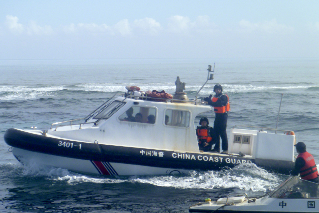 In this Dec. 24, 2015, photo, provided by Filipino fisherman Renato Etac, a Chinese Coast Guard boat approaches Filipino fishermen near Scarborough Shoal in the South China Sea.  A landmark ruling on an arbitration case filed by the Philippines that seeks to strike down China's expansive territorial claims in the South China Sea will be a test for international law and world powers. China, which demands one-on-one talks to resolve the disputes, has boycotted the case and vowed to ignore the verdict, which will be handed down Tuesday, July 12, 2016,  by the U.N. tribunal in The Hague.(Renato Etac via AP)