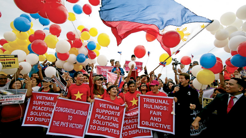 STREET CELEBRATION Breaking into loud cheers, a crowd of Filipinos and Vietnamese at Manila Bay hoist a giant Philippine flag on Tuesday to show their support for the unanimous decision of a UN-backed tribunal to junk China’s claim to almost all of the South China Sea, including waters in Manila’s exclusive economic zone known as  West Philippine Sea. RICHARD A. REYES