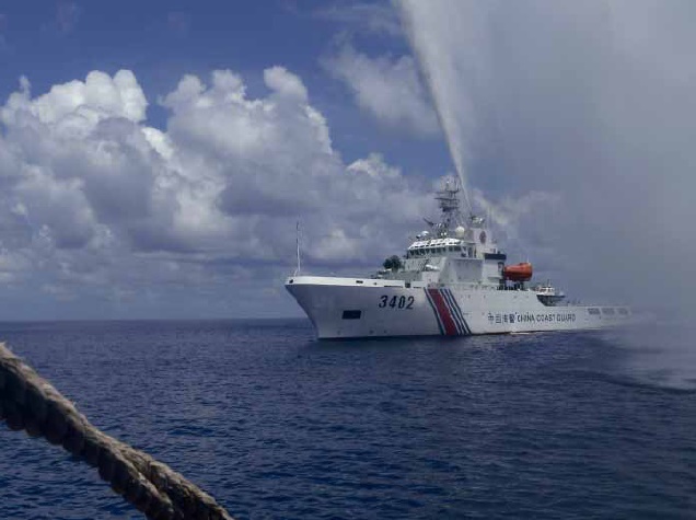 In this Sept. 23, 2015, file photo, Chinese Coast Guard members approach Filipino fishermen as they confront each other off Scarborough Shoal in the South China Sea, also called the West Philippine Sea. A look at some recent key developments in the South China Sea, where China is pitted against smaller neighbors in multiple disputes over islands, coral reefs and lagoons in waters crucial for global commerce and rich in fish and potential gas and oil reserves. (AP Photo/Renato Etac, File) 