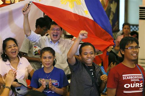 Filipinos applaud moments after the Hague-based U.N. international arbitration tribunal ruled in favor of the Philippines in its case against China on the dispute in South China Sea Tuesday, July 12, 2016 in Manila, Philippines. The tribunal has found that there is no legal basis for China's "nine-dash line" claiming rights to much of the South China Sea. The tribunal issued its ruling Tuesday in The Hague in response to an arbitration case brought by the Philippines against China. AP Photo
