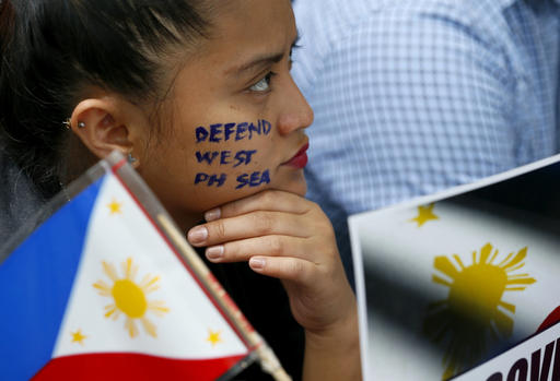 In this Friday, June 10, 2016, file photo, a protester has her cheek painted with a slogan outside the Chinese Consulate during a protest against China's occupation and island-building in the disputed Spratly Island group in the South China Sea, in Makati city's financial district east of Manila, Philippines. A case brought by the Philippines against China in an international tribunal deciding the claim, represents a diplomatic dilemma for far-flung nations as Washington and Beijing rally support for their respective positions on the use of international arbitration in South China Sea disputes. AP FILE PHOTO