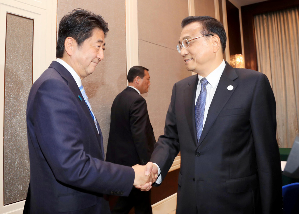 Chinese Premier Li Keqiang, right, and Japanese Prime Minister Shinzo Abe shake hands during a bilateral meeting held on the sideline of the 11th Asia-Europe Meeting (ASEM) Summit in Ulaanbaatar, Mongolia, Friday, July 15, 2016. (Kyodo News via AP) JAPAN OUT, CREDIT MANDATORY
