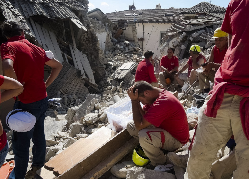 Rescuers pause in Amatrice, central Italy, where a 6.1 earthquake struck just after 3:30 a.m., Wednesday, Aug. 24, 2016. The quake was felt across a broad section of central Italy, including the capital Rome where people in homes in the historic center felt a long swaying followed by aftershocks. (AP Photo/Emilio Fraile)