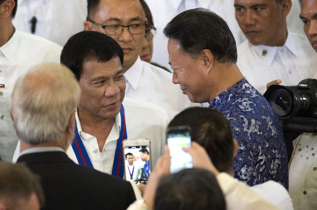 Philippine President Rodrigo Duterte, left, talks with Chinese Ambassador to the Philippines Zhao Jianhua, right, during the 115th Police Service Anniversary at the Philippine National Police (PNP) headquarters in Manila Wednesday, Aug. 17, 2016.  The brash-talking Philippine president criticized the United Nations Wednesday for condemning the spate of killings of suspected drug criminals in the country, but allegedly remaining silent on bombings in the Middle East that have killed entire villages and communities. (Noel Celis/Pool Photo via AP)