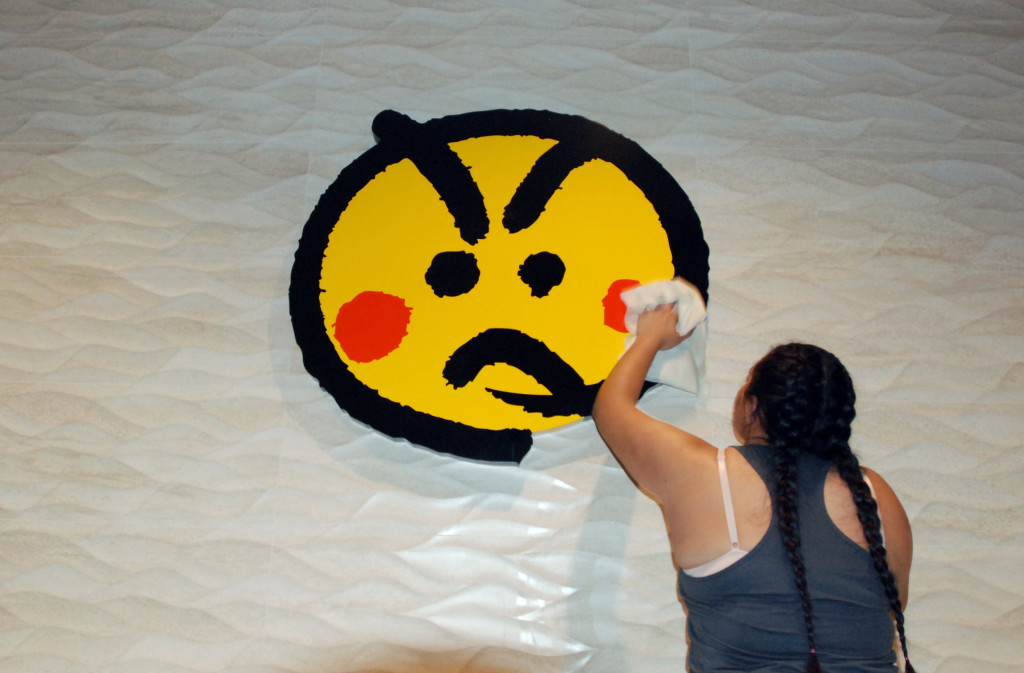 An employee cleans a logo at the Genki Sushi conveyor belt restaurant chain Tuesday, Aug. 16, 2016, in Aiea, Hawaii. The Hawaii State Department of Health Sanitation said Tuesday that Genki Sushi is being ordered to close its 10 restaurants on Oahu and one on Kauai after state authorities identified its raw scallops as the probable source of a hepatitis A outbreak. The disease can cause fever, loss of appetite and other symptoms. (AP Photo/Caleb Jones)