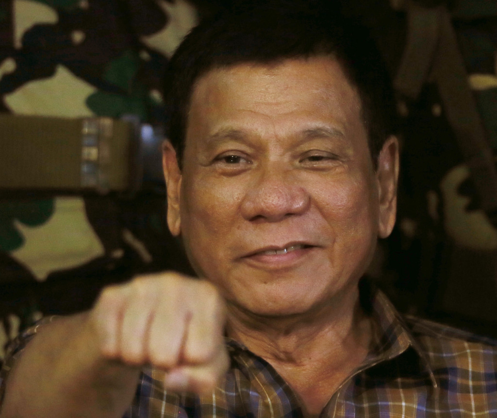 FILE - In this Aug. 25, 2016, file photo, Philippine President Rodrigo Duterte gestures with a fist bump during his visit to the Philippine Army's Camp Mateo Capinpin at Tanay township, Rizal province east of Manila, Philippines. Duterte raised his bloody anti-crime war rhetoric to a new level Friday, Sept. 30, 2016, comparing it to how Hitler massacred millions of Jews and saying how he would be "happy to slaughter" 3 million addicts. Duterte issued his latest threat against drug dealers and users early Friday on returning to his home in southern Davao city after visiting Vietnam, where he discussed his anti-drug campaign with Vietnamese leaders and compared notes on battling the problem. (AP Photo/Bullit Marquez, File)