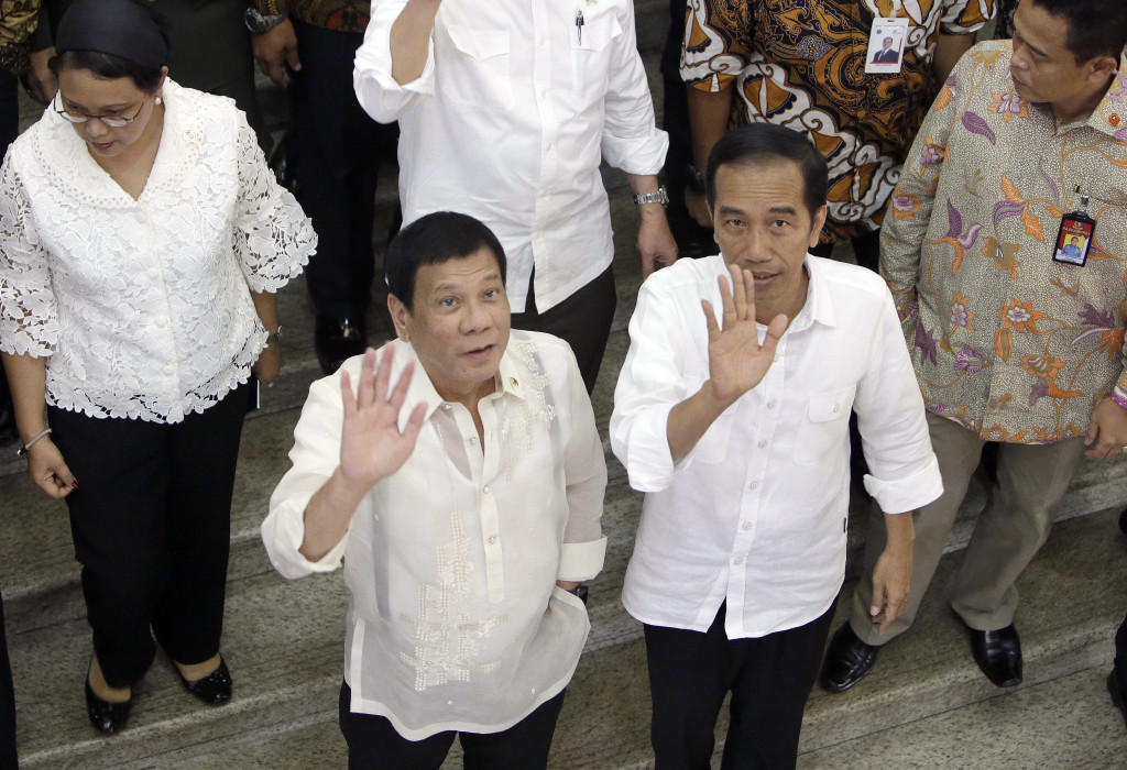 Philippines' President Rodrigo Duterte, center left, waves with his Indonesian counterpart Joko Widodo during their visit at Tanah Abang Market on the sidelines of their meeting in Jakarta, Indonesia, Friday, Sept. 9, 2016. Duterte is currently on a two-day visit to the country. AP 