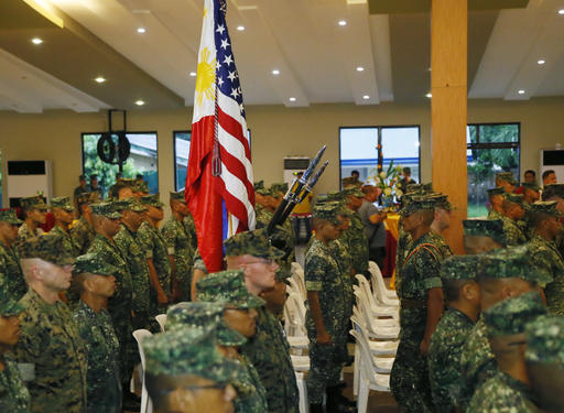 U.S. Marines from the 3rd Marine Expeditionary Brigade and their Philippine counterpart stand at attention at the exit of colors to end the 33rd joint U.S.-Philippines amphibious landing exercises dubbed PHIBLEX at the marines corps in suburban Taguig city, east of Manila, Philippines Tuesday, Oct. 11, 2016. The Philippine president says he will not abrogate a defense treaty with the United States but is questioning its importance and that of joint combat exercises, which he says only benefit America. President Rodrigo Duterte criticized the United States and his country's engagement with the American military in a speech Tuesday as Philippine marines and their American counterparts ended combat drills a day early. (AP Photo/Bullit Marquez)
