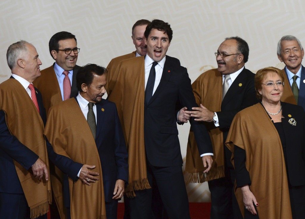Canada's Prime Minister Justin Trudeau jokes around with fellow leaders during the group photo at the annual Asia Pacific Economic Cooperation, APEC, summit in Lima, Peru, Sunday, Nov. 20, 2016. The APEC forum closed with a joint pledge to work toward a sweeping new free trade agreement that would include all 21 members as a path "sustainable, balanced and inclusive growth," despite the political climate. (Sean Kilpatrick /The Canadian Press via AP)