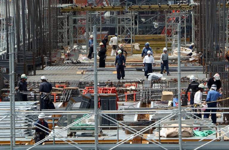 Construction workers labour at a large building in Tokyo on May 20, 2015. Japan's economy grew more than expected in the first three months of the year as it crawls back from a brief recession, but observers cautioned that a strong recovery may still be some way off. The 0.6 percent on-quarter expansion was bigger than revised 0.3 percent growth in the last three months of 2014, and beat market expectations for a 0.4 percent rise.   AFP PHOTO / Yoshikazu TSUNO / AFP PHOTO / YOSHIKAZU TSUNO