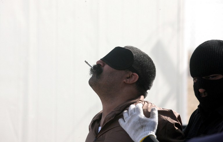 A Saudi man smokes his last cigarette before being hanged for the murder of a compatriot just west of the capital Kuwait City, on April 1,2013. Authorities in Kuwait hanged three convicted murderers, a Pakistani, a Saudi and a stateless Arab, in the first executions in the Gulf state since May 2007, the ministry of justice said. AFP PHOTO/YASSER AL-ZAYYAT / AFP PHOTO / YASSER AL-ZAYYAT