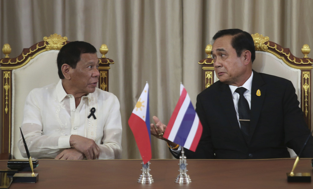 Philippine President Rodrigo Duterte, left, talks to Thailand's Prime Minister Prayuth Chan-ocha during the agreements signing involving agriculture, education, energy, science and technology at the government house in Bangkok, Thailand, Tuesday, March 21, 2017. Duterte is in Thailand for a two-day visit rounding out his nine-country tour of southeast Asia. (AP Photo/Sakchai Lalit)