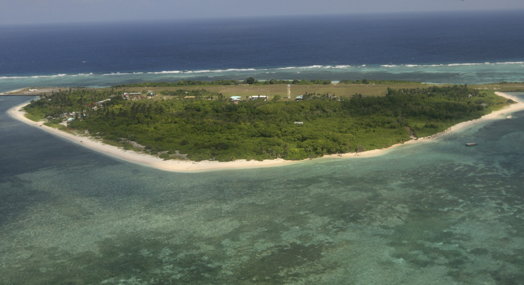 This July 20, 2011 file aerial photo, taken through the window of a closed aircraft, shows Pag-asa Island, part of the disputed Spratly group of islands, in the South China Sea located off the coast of western Philippines.  Philippine President Rodrigo Duterte said Thursday, April 6, 2017, that structures should be built on all of the nine to 10 islands, reefs and shoals held by the Philippines in the Spratly Islands.  Duterte said he may visit one of the islands, Pag-asa, to plant a Philippine flag on Independence Day. He said money has been budgeted to repair the runway on Pag-asa, home to a small fishing community and Filipino troops.   (AP Photo/Rolex Dela Pena, Pool, File)