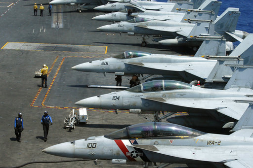 FILE - In this March 3, 2017 file photo, a row of F18 fighter jets on the deck of the USS Carl Vinson is prepared for patrols when the U.S. Navy took Philippine journalists to the mammoth aircraft carrier on routine patrol in the waters off the disputed South China Sea. The Pentagon says a Navy carrier strike group is moving toward the western Pacific Ocean to provide a physical presence near the Korean Peninsula. North Korea's recent ballistic missile tests and continued pursuit of a nuclear program have raised tensions in the region, where U.S. Navy ships are a common presence and serve in part as a show of force. The U.S. Pacific Command directed the carrier group, that includes the USS Carl Vinson, to sail north to the western Pacific after departing Singapore on Saturday, April 8, according to a Navy news release. (AP Photo/Bullit Marquez, File)