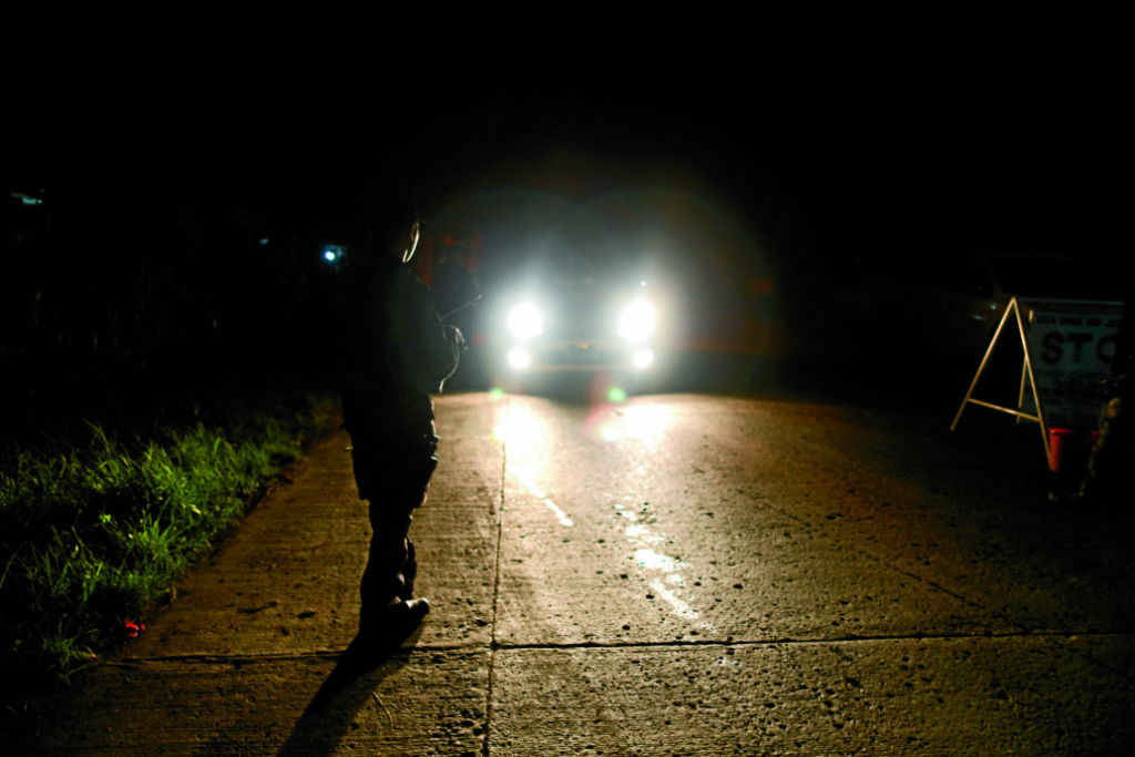 Police inspect vehicles passing along he national highway in Kapatagan, Lanao del Sur on Tuesday night as President Duterte declares martial law all over Mindanao.