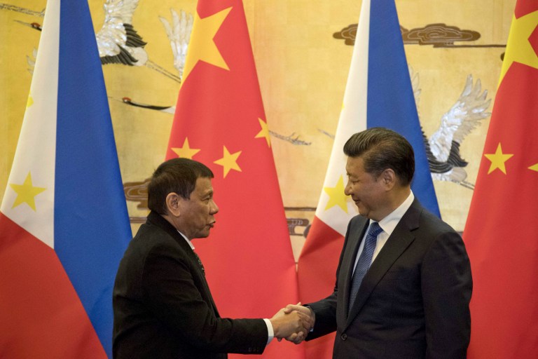 Philippines' President Rodrigo Duterte (L) and his Chinese counterpart Xi Jinping shake hands after a signing ceremony in Beijing on October 20, 2016.  Duterte met with his Chinese counterpart Xi on October 20, state media said, as the Philippines leader seeks closer ties with the Asian giant while blasting his US allies. / AFP PHOTO / POOL