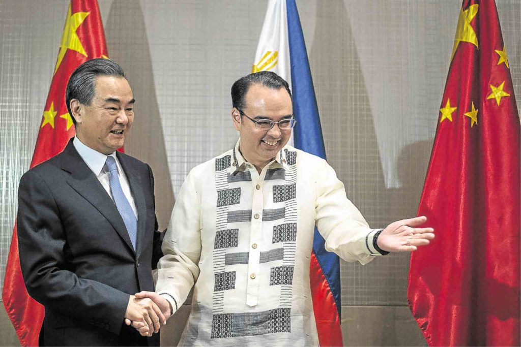WIN-WIN DEAL Chinese Foreign Minister Wang Yi and Foreign Secretary Alan Peter Cayetano support joint venture in the South China Sea. —AFP