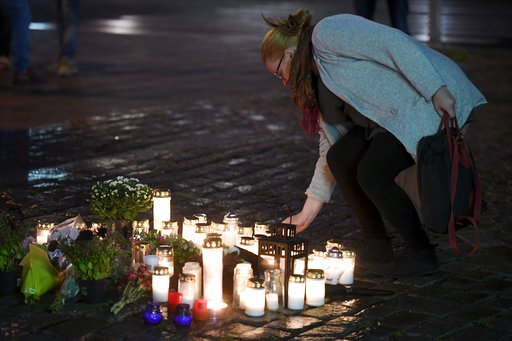 A woman places a memorial candle at the Market Square for the victims of Friday's stabbings in Turku, Finland, on Friday evening, Aug. 18, 2017. AP