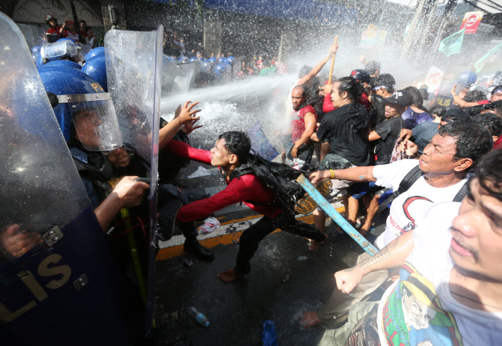 DISPERSED Activists protesting the visit of US President Donald Trump to the country are dispersed by riot police using water cannons during a rally alongUNAvenue in Manila. —MARIANNE BERMUDEZ